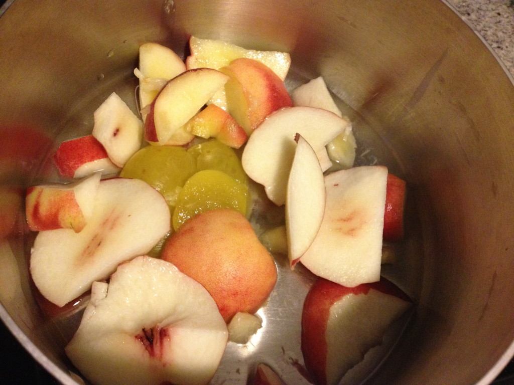 Peaches, plums and nectarines in a saucepan cooking down to turn into a puree