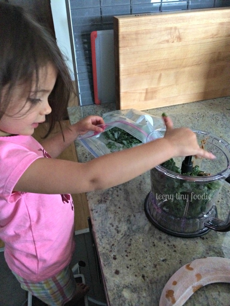 Putting frozen kale in the blender to make a Nutty Green Smoothie from teeny tiny foodie